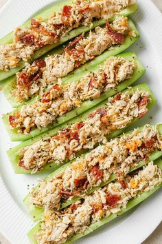 celery spears filled with chicken salad on a white plate