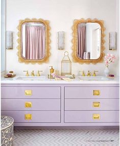 a bathroom with two sinks and mirrors on the wall above them is decorated in pink and gold