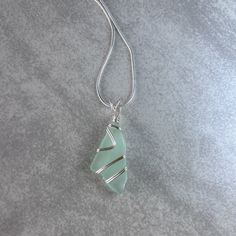 a green pendant is sitting on a gray surface