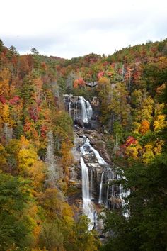 a waterfall surrounded by trees in the fall