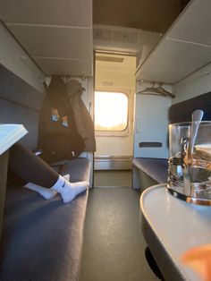 a person sitting on a bench in the back of an airplane with their feet propped up