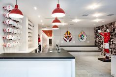 a room filled with lots of white counter top next to red and black lights hanging from the ceiling