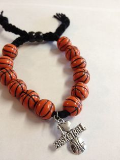 an orange and black beaded bracelet with a cross charm