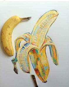 a drawing of a banana on a white surface with scissors and other items around it