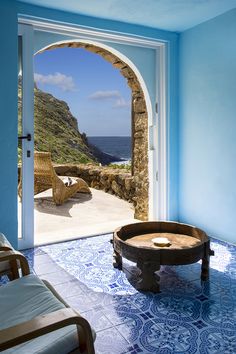 an open door leading to a patio with a view of the ocean