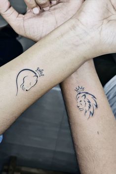 two people are holding hands with tattoos on their arms, one has a lion and the other has a crown