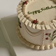 a birthday cake decorated with roses and the words happy birthday written in frosting on it