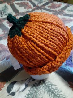 an orange knitted hat sitting on top of a table