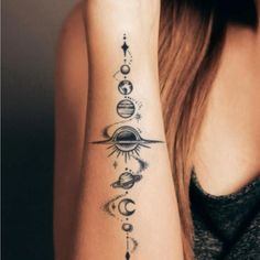 a woman with a tattoo on her arm that has planets and stars in the sky