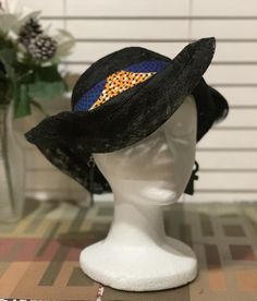 For those fun days out  add a Zulu lace  hat to your wardrobe. This lace crown has six different looks. The hat was inspired by my friendship with the Zulu women from Johasurburgh, from  South Africa.  Turn the hat to fit your mood. Every turn is a different expression. The  kente cloth band is removable.  This is a black lace hat with kente cloth. There is lace strings inside to give you the proper fit.  This hat is pack friendly. This is a   nice and simple statement that will turn heads. Grea Black Top Hat For Summer Church Events, Black Top Hat For Church In Summer, Black Summer Top Hat For Church, Black Fitted Bucket Hat, Black Brimmed Hat For Races, Black Brimmed Sun Hat For Kentucky Derby, Black Curved Brim Bucket Hat For Festivals, Black Brimmed Boater Hat For Races, Black Brimmed Top Hat For Summer