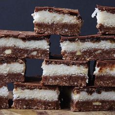 several pieces of chocolate and coconut bars stacked on top of each other