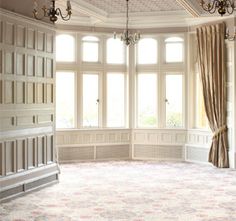 an empty room with chandeliers and windows