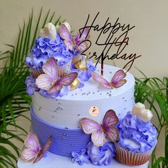 a birthday cake decorated with purple flowers and butterflies