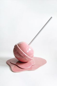 a pink object with a white stick sticking out of it's center on a plate