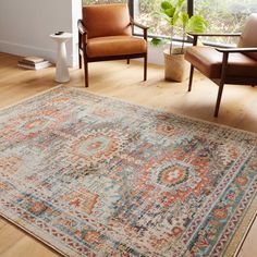 a living room with two chairs and a rug