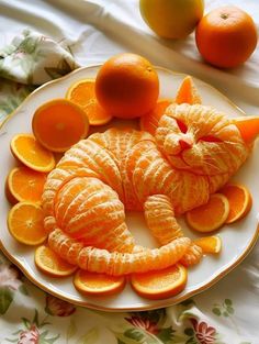 an orange cat made out of fruit on a plate