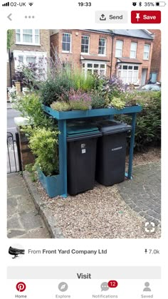 an image of two trash cans in the middle of a yard with plants growing out of them