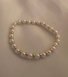 This listing is for one beaded boho bracelet. This bracelet has dainty beads that are strung on strong elastic. The gold beads are gold plated and will not tarnish, and the pearl beads are spherical. The bracelets are double knotted and glued shut. This bracelet would be a cute friendship bracelet, gift for a best friends, or a gift for her. Pearl And Gold Bracelet, Braclate Ideas, Pearl Bracelet Ideas, White Clay Bead Bracelet, Cute Beaded Jewelry, Cute Beaded Bracelets, Beads Bracelet Ideas, Gold And Pearl Bracelet, Gold Beaded Bracelets