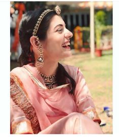 an image of a woman with jewelry on her neck and face, looking up at the sky