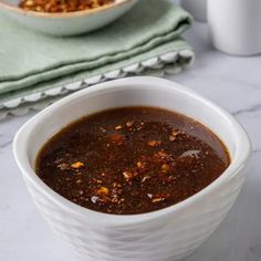 a white bowl filled with chili sauce on top of a table