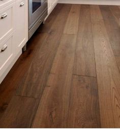 a kitchen with wood floors and white cabinets