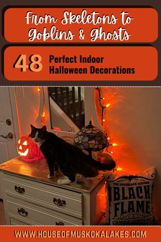 a black and white cat sitting on top of a dresser next to a halloween decoration