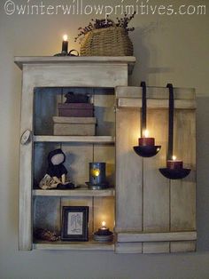 a shelf with candles and pictures on it