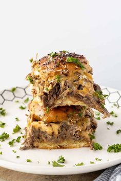 two stacked sandwiches on a white plate with parsley