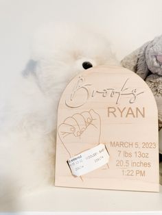 a teddy bear is next to a wooden sign