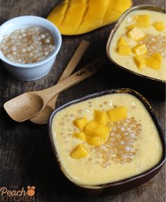 two bowls filled with mango and oatmeal on top of a wooden table