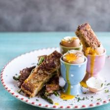 a plate with some food on it and an egg in a cup next to it