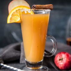 an apple cider is garnished with orange slices and cinnamon