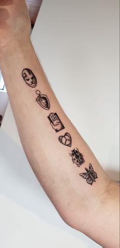 a person with a tattoo on their arm that has different things in it and is holding up the arm