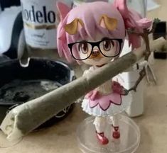 a doll with glasses is standing on a branch