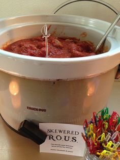 a bucket filled with lots of food on top of a table next to a sign