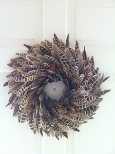 a wreath made out of feathers hanging on a door