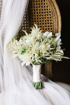 a bouquet of white flowers sitting on top of a chair