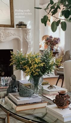 a living room filled with lots of furniture and flowers on top of a glass table