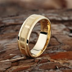 a gold wedding ring sitting on top of a rock