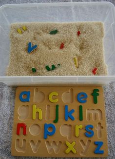 a plastic tray with letters and numbers in it next to a plastic container filled with rice