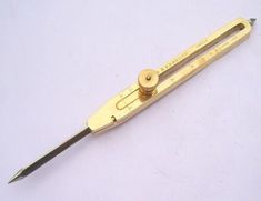 a pair of gold scissors sitting on top of a white table