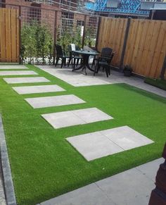 an outdoor patio with grass and stepping stones