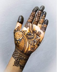 a woman's hand with henna tattoos on it and her hands painted brown