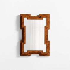 a mirror that is on the wall next to a white wall with a wooden frame