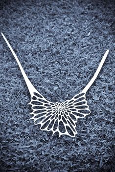 Silicone rubber is cut by lasercut into an organic network of distorting ellipses. The pattern displays shifts in direction and scale, creating a sense of movement and tension. These complex forms recall those of radiolarians, plant cells and even the familiar honey comb. This necklace is formed in one piece and fastens in the back with a sliding mechanism that allows for variable lengths. Silicone rubber is an odorless and heat resistant rubber. Its high tensile strength allows the necklace to Tech Jewelry, Space Jewelry, 3d Printed Jewelry, Laser Cut Jewelry, Printed Jewelry, Bib Necklaces, Negative Space, Silicone Rubber, Nervous System