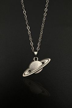 Immerse yourself in the cosmic beauty of the universe with our handcrafted Space Saturn Necklace. This celestial accessory is more than just a piece of jewelry - it's an expression of your love for the cosmos. Perfect for both men and women, this unique piece combines aesthetic design and intricate craftsmanship, making it an outstanding addition to your jewelry collection or a thoughtful gift for the space enthusiasts in your life. Please note: as each piece is handmade, slight variations may o Saturn Jewelry, Planets Saturn, Space Saturn, Saturn Pendant, Saturn Necklace, Planet Necklace, Space Jewelry, Space Planets, Space Gift