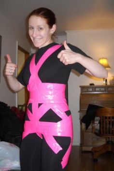 a woman in a pink and black costume giving the thumbs up