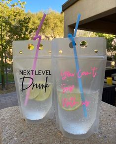 two plastic cups with straws and lemon in them