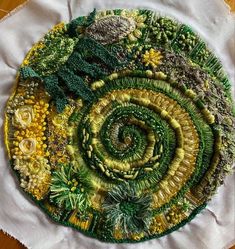 a close up of a plate on a table with green and yellow flowers in the center