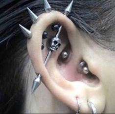 an ear with some piercings attached to it's sides and two different sized spikes